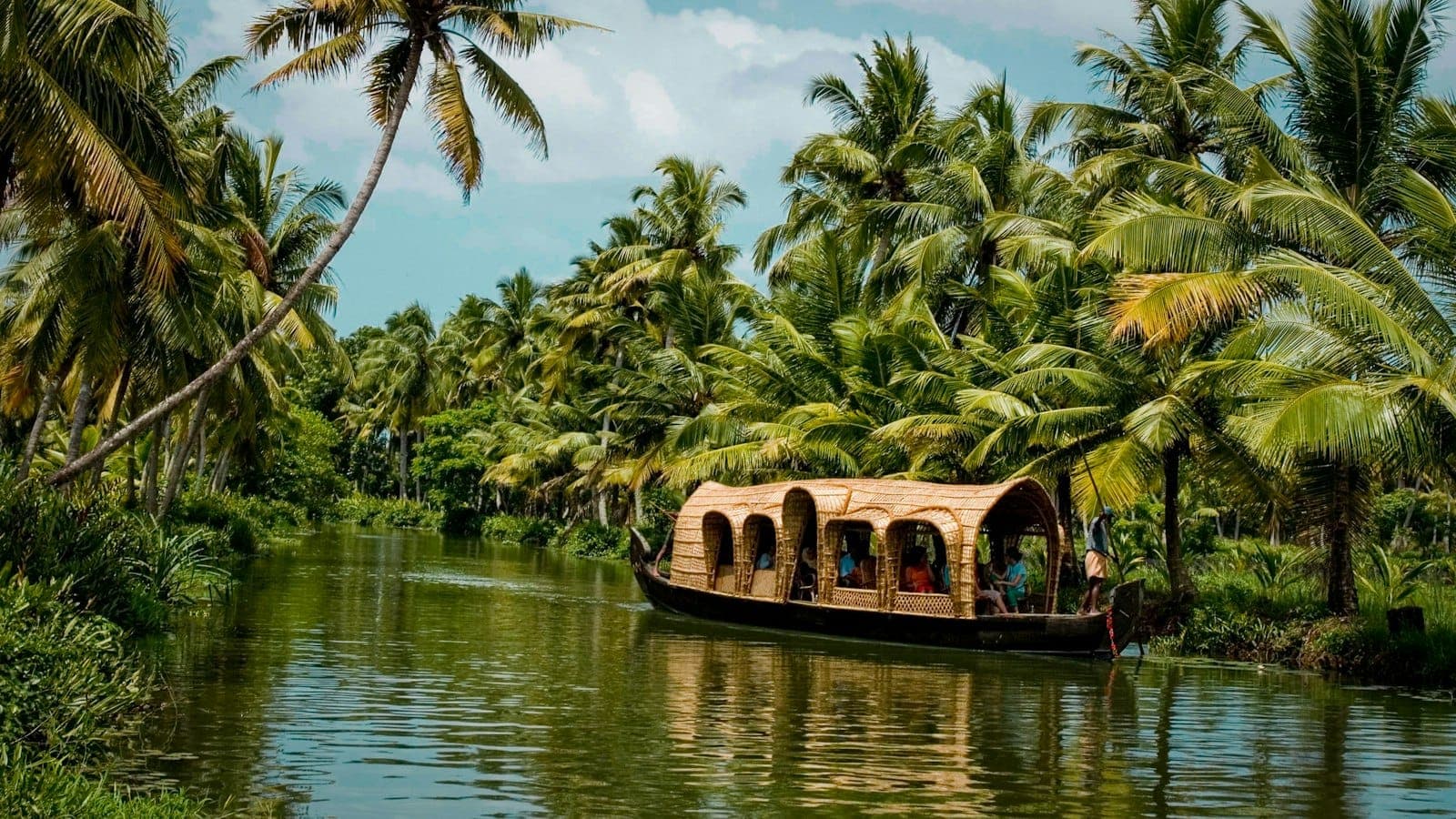 Houseboat on the Kerala backwaters under coconut palms